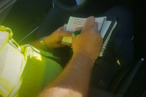 Policjant ruchu drogowego wypisujący Mandat Karny Kredytowany.